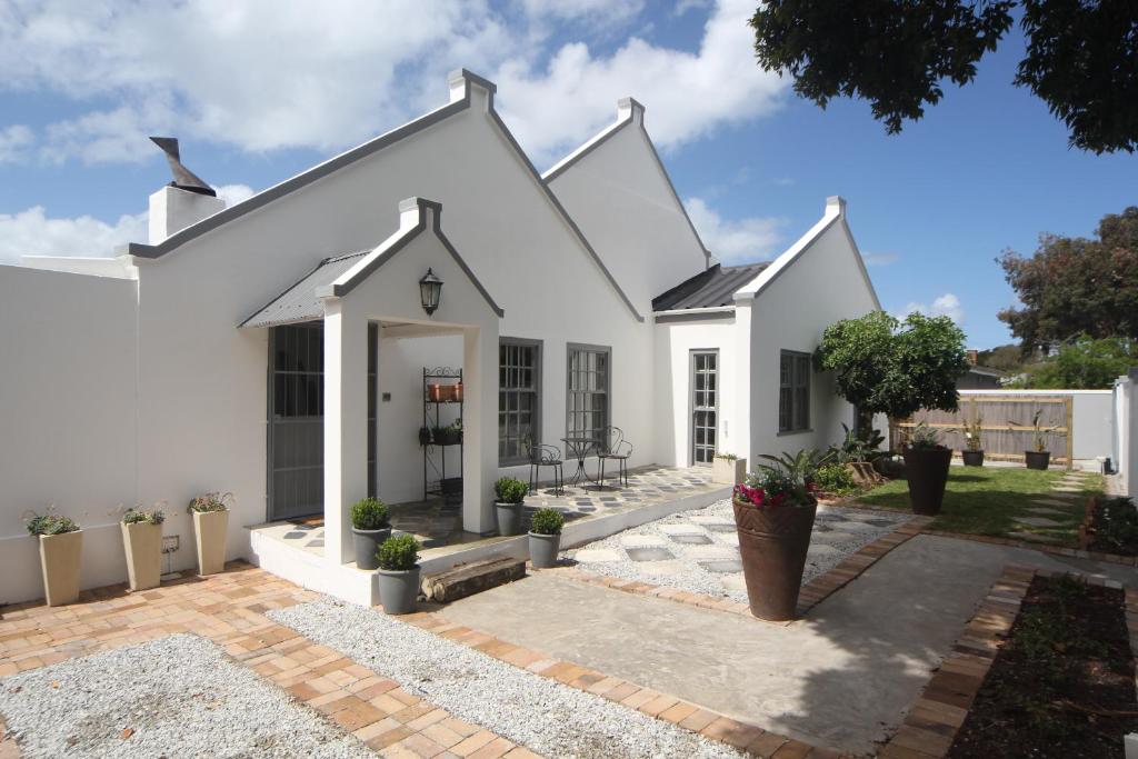 una casa blanca con un patio frente a ella en The Lily House, en Hermanus