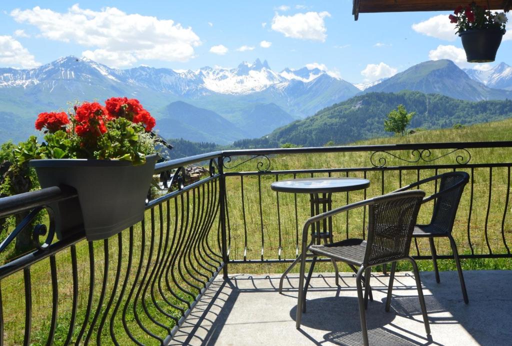 uma mesa e cadeiras numa varanda com vista para as montanhas em Le Petit Chalet-Leard em Jarrier
