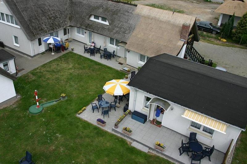 einem Luftblick auf ein Haus mit einer Terrasse und einem Sonnenschirm in der Unterkunft Ferienhof Schön in Zempin