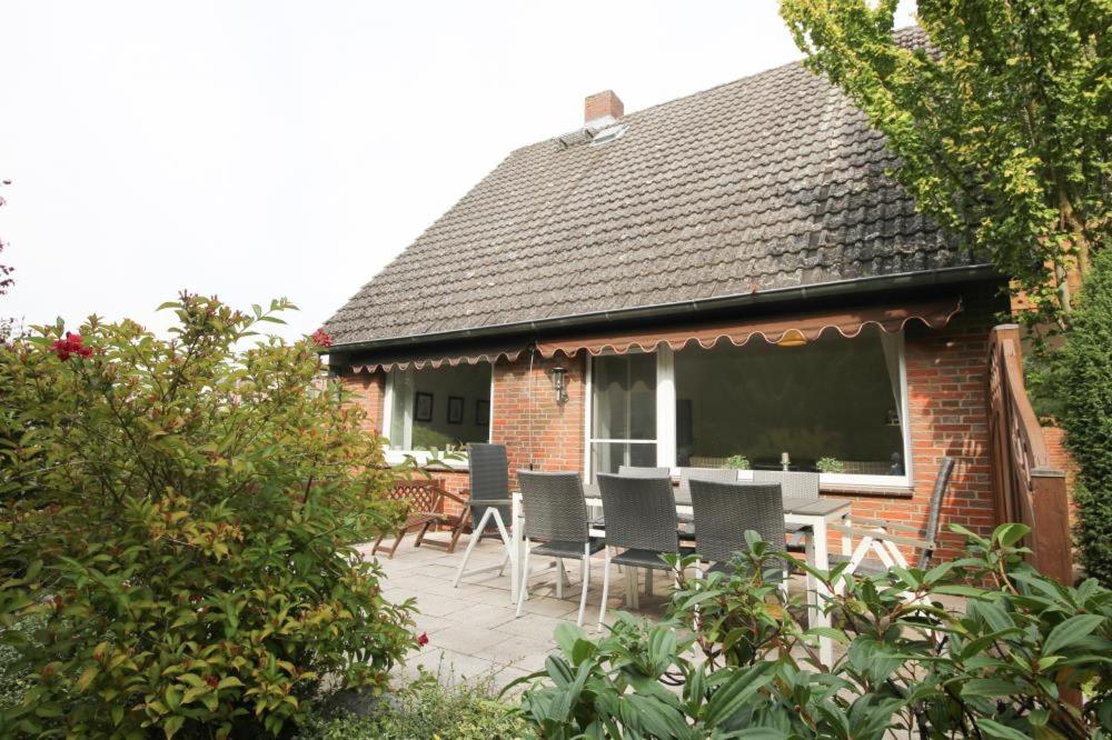 ein Haus mit einer Terrasse mit Stühlen und einem Fenster in der Unterkunft Ferienhaus Strandräuber in Timmendorfer Strand