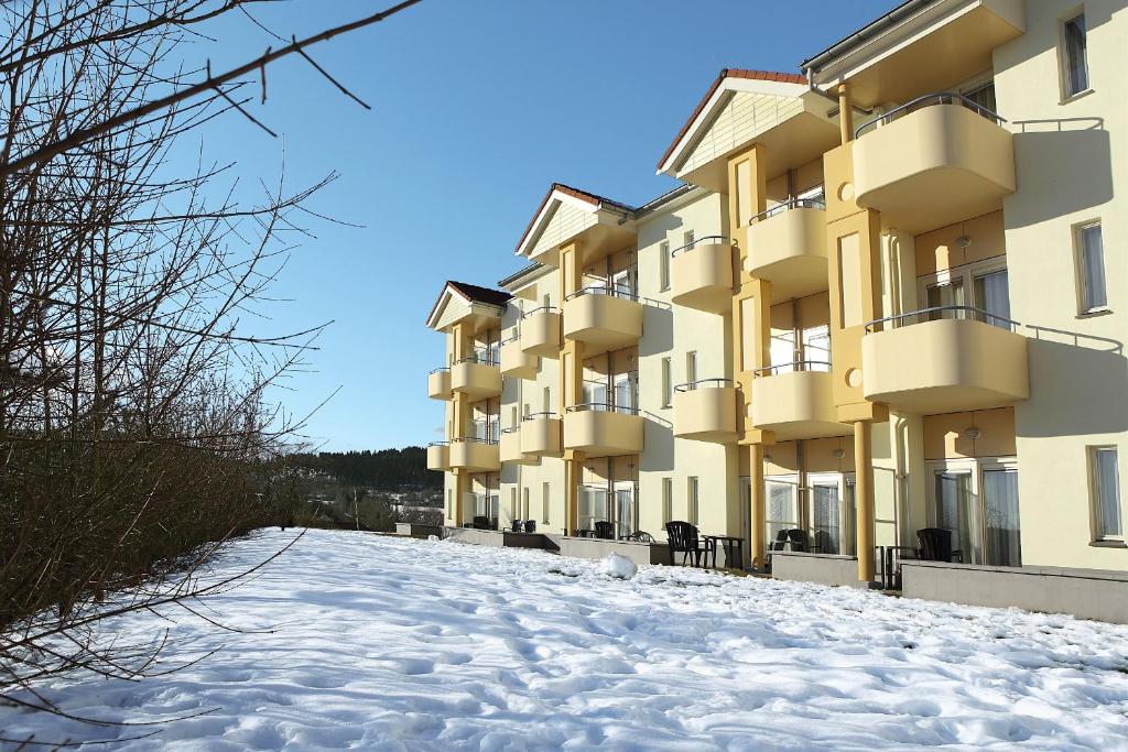 a snow covered street in front of a building at Hotel Hochsauerland by Center Parcs in Medebach