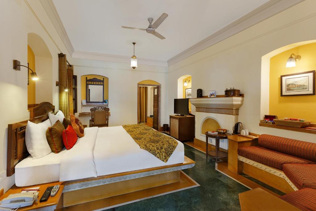 ein Hotelzimmer mit einem Bett und einem Kamin in der Unterkunft The Haveli Hari Ganga by Leisure Hotels in Haridwar