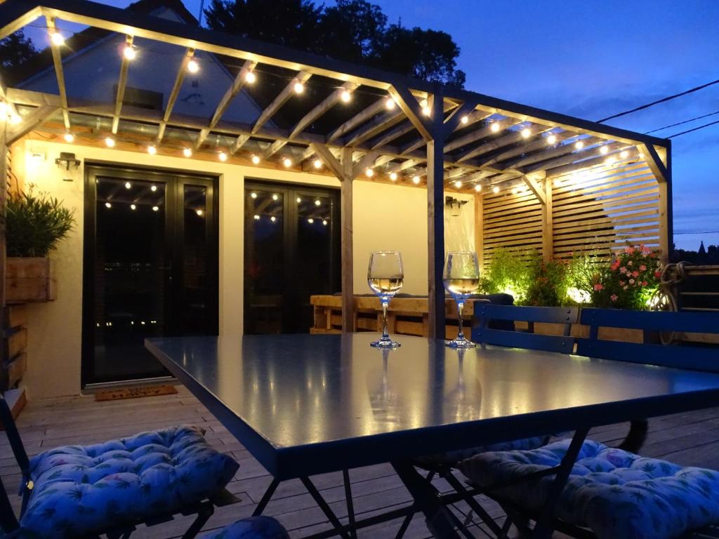 a table with wine glasses on a patio with lights at Casa Juno in Duvy