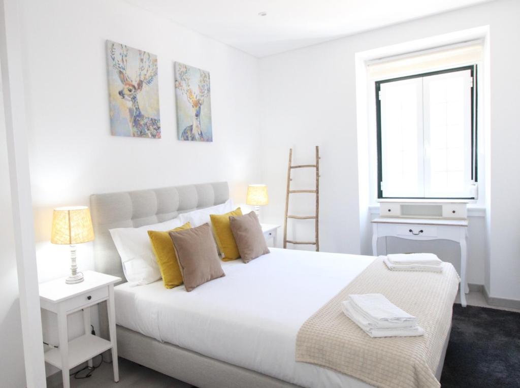 a white bedroom with a large bed and a window at Apartamento Moderno nas Olaias a 5 minutos da Faculdade ISEL e IST in Lisbon