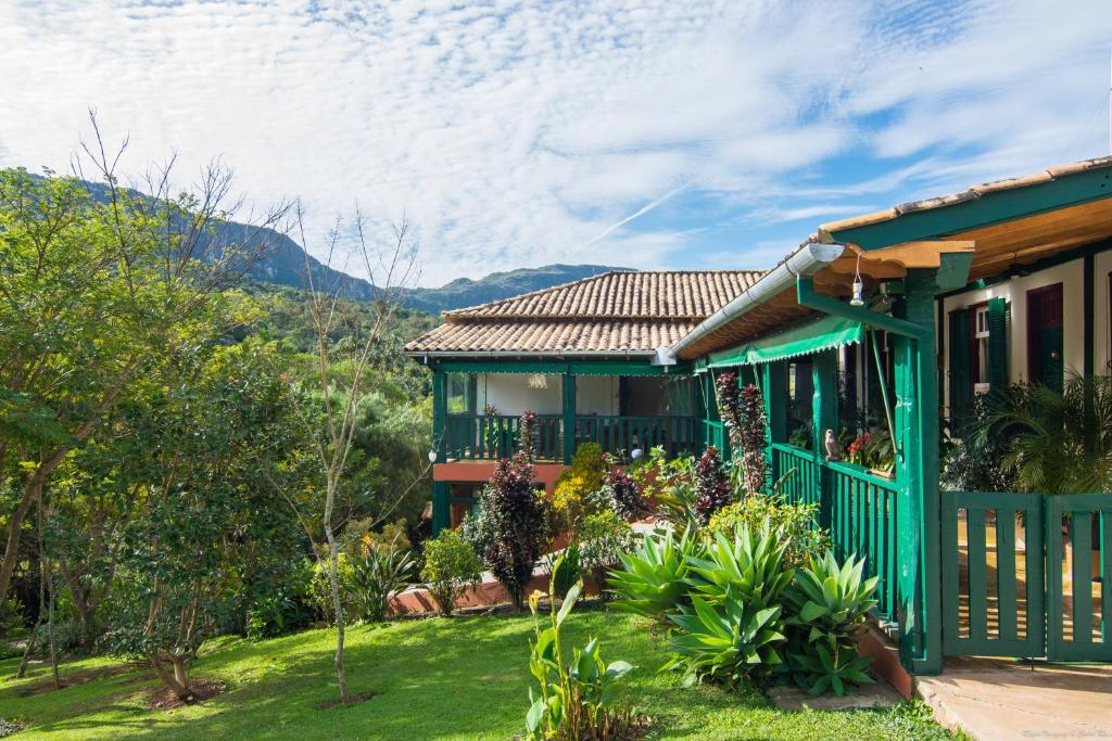 ein grünes Haus mit einem Garten davor in der Unterkunft Pousada da Trilha in Tiradentes