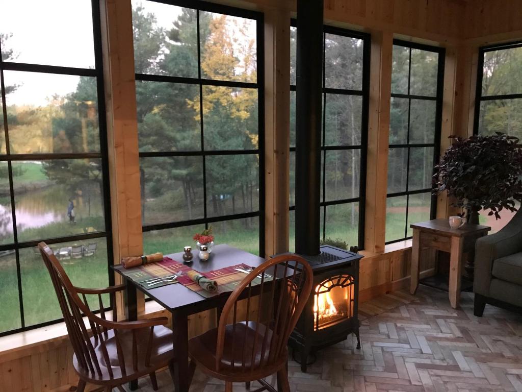 a dining room with a table and chairs and windows at Inn at the River in Wausau