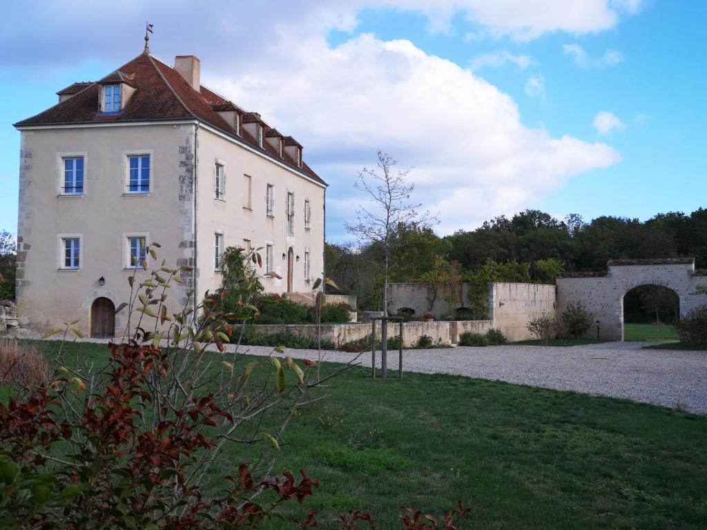 een groot wit gebouw met een rood dak bij Le Prieuré de Loups in Saint-Michel-en-Brenne