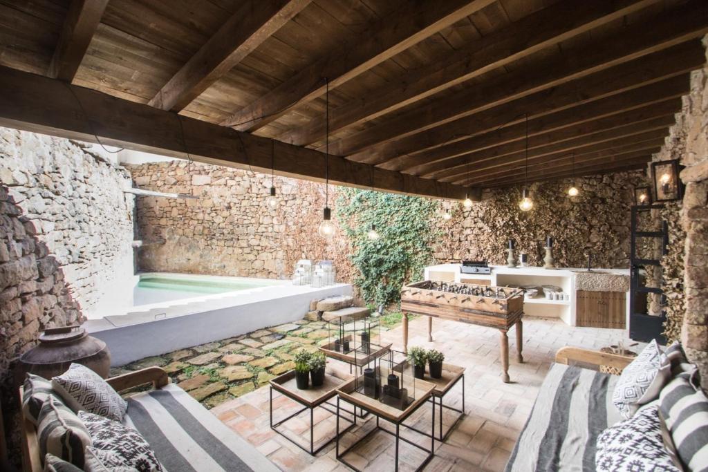 an outdoor living room with a stone wall and a tub at Valencia Luxury - Mora de Rubielos con Piscina in Mora de Rubielos