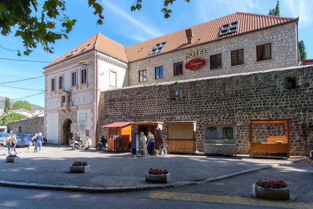 a large brick building with people standing outside of it at Integra Hotel in Trebinje