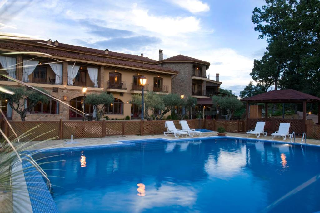 a swimming pool in front of a house at Hotel Ruta Imperial in Jarandilla de la Vera