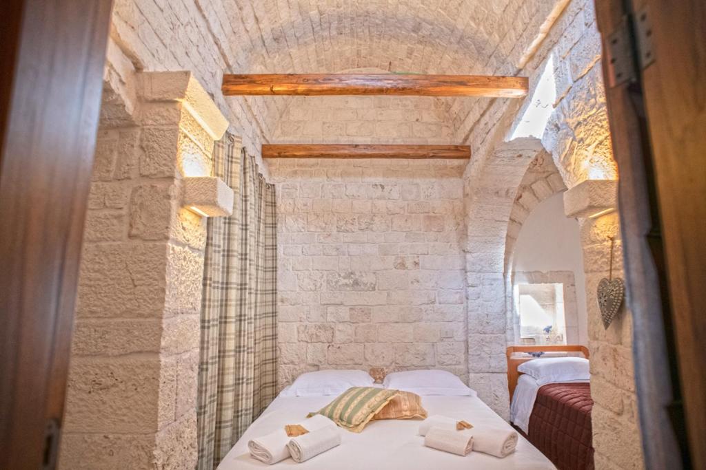 a bedroom with a bed in a brick wall at IL TRULLO GENTILE ALBEROBELLO in Alberobello