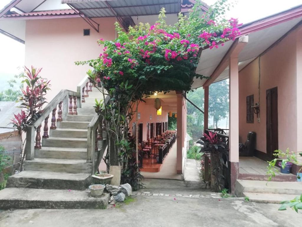 ein Gebäude mit einer Treppe mit Blumen darauf in der Unterkunft Meexai Guesthouse in Nongkhiaw