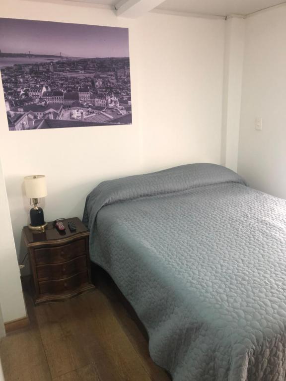 1 dormitorio con 1 cama y 1 mesa con lámpara en Apt estudio nororiente, en Bogotá
