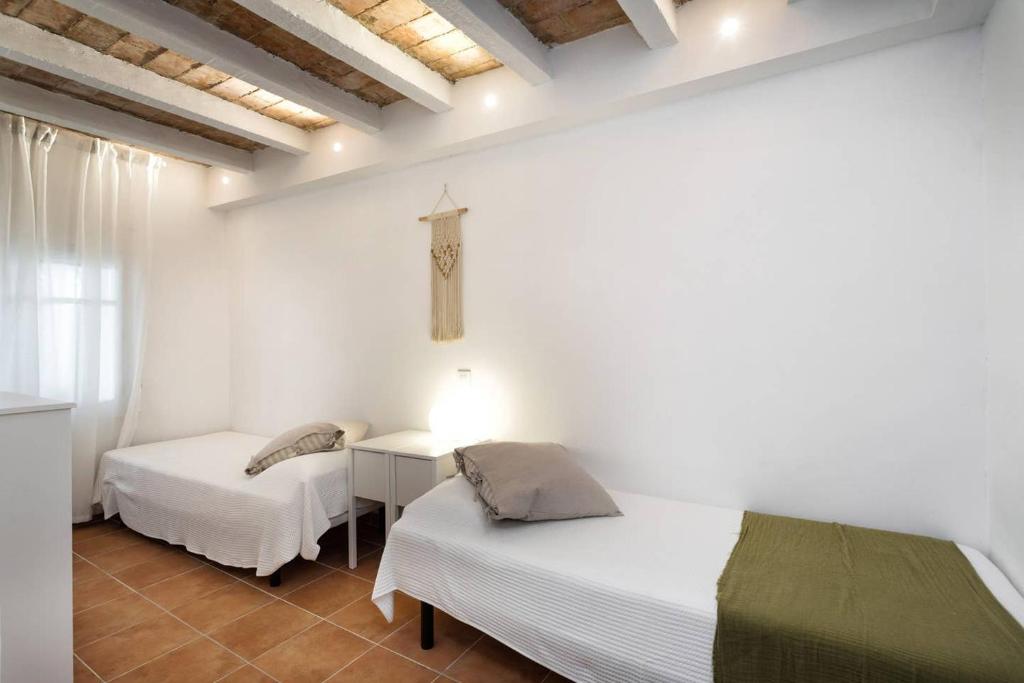 a bedroom with two beds and a cross on the wall at Can Terrats in Blanes