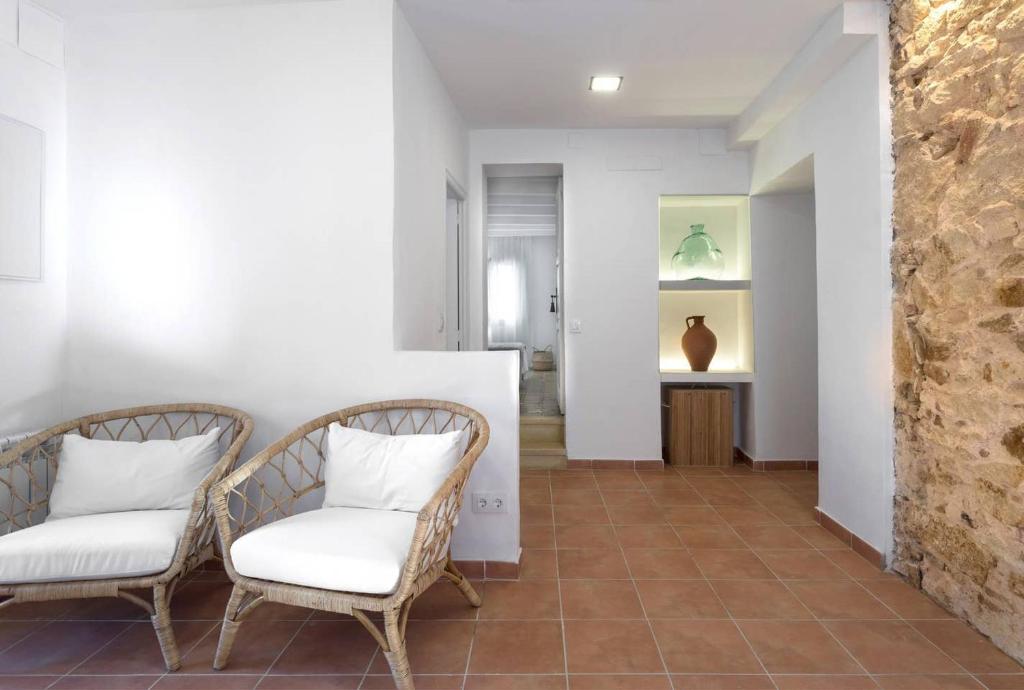 a hallway with two chairs with white pillows at Can Terrats in Blanes
