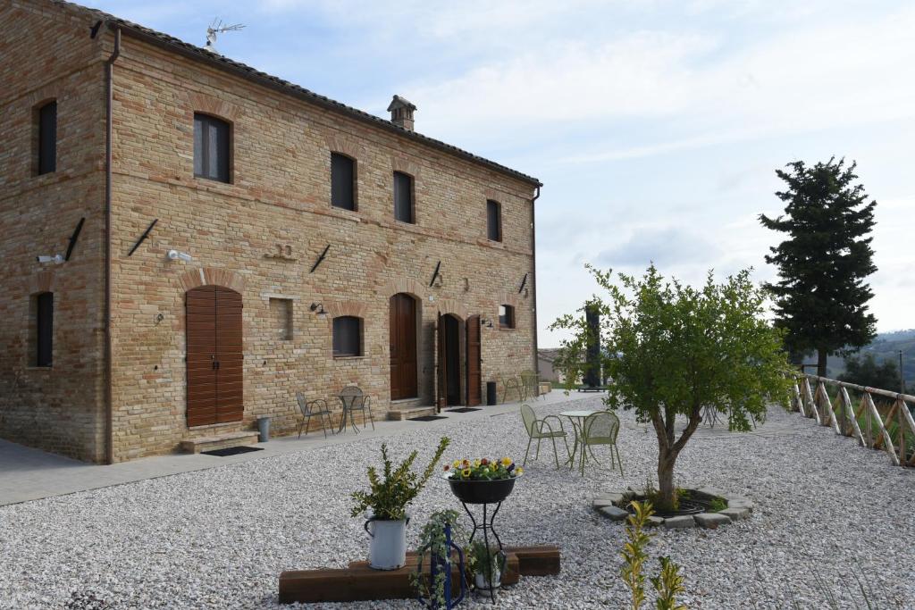 un gran edificio de ladrillo con un árbol delante de él en Villa Shmitanka en Servigliano