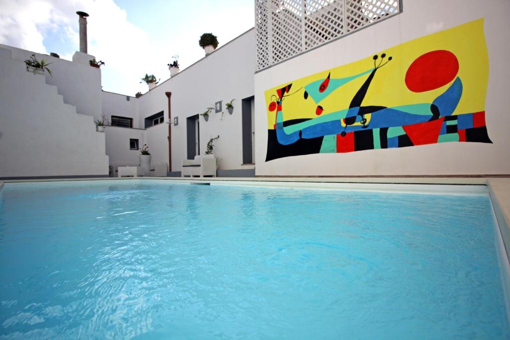 a swimming pool with a painting on the side of a building at Salentuosi - Salento Mille e una Notte in Racale