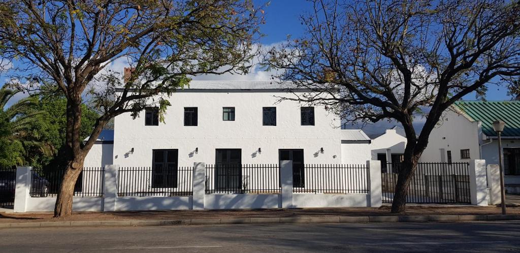 a white house with a fence in front of it at Hayburg House in Robertson