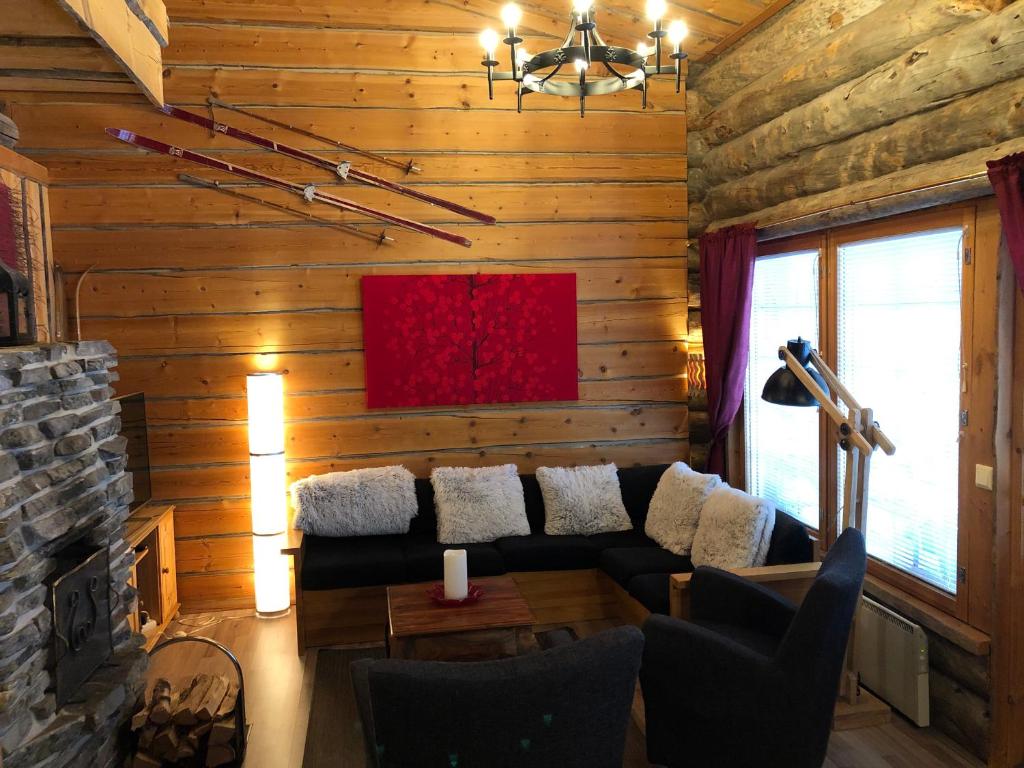 a living room with a couch and a fireplace at Rukan Otsolanhovi in Ruka
