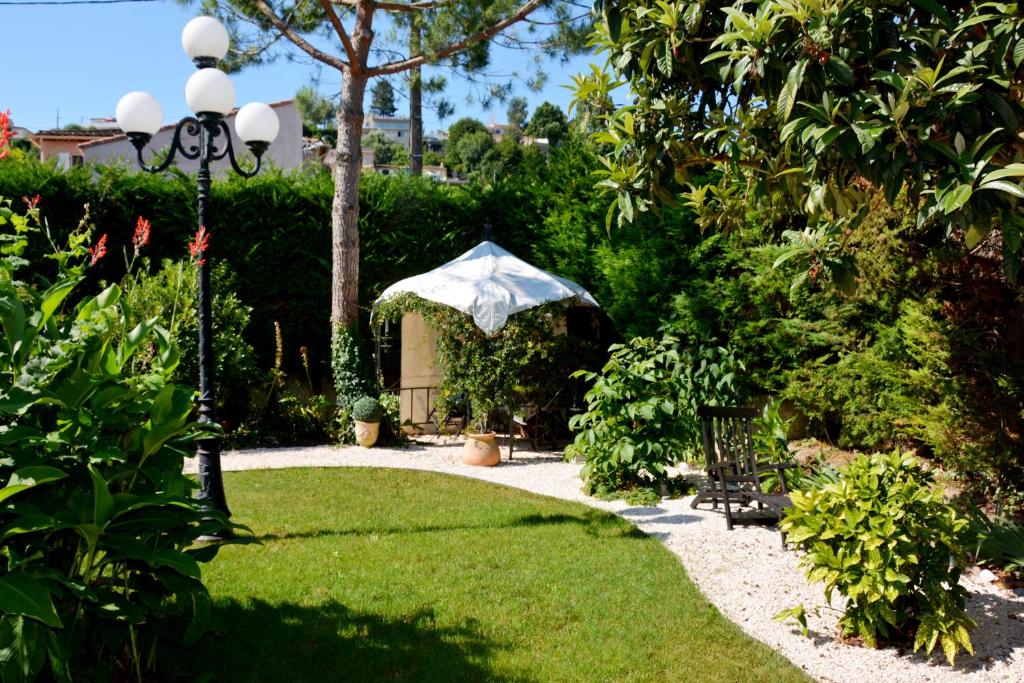 un jardin avec une table et un parasol dans l'établissement Villa 2P VLB, à Villeneuve-Loubet