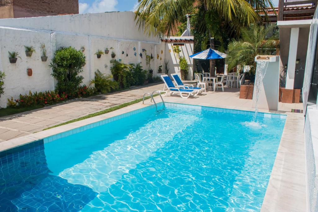 una piscina blu con una sedia e un tavolo di Hotel Pousada Da Sereia a Maceió