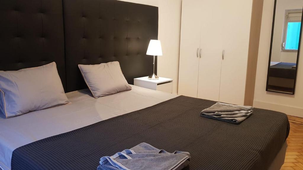 um quarto com uma cama grande e uma cabeceira preta em Greater Lisbon Cozy 2B Apartment - Odivelas em Odivelas