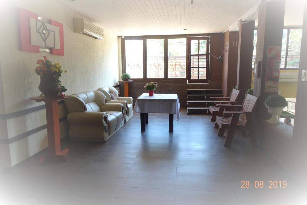 sala de estar con sofá y mesa en Hotel La Gran Manzana en Puerto Iguazú
