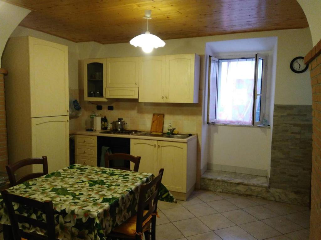 a kitchen with a table and a kitchen with a table and chairs at Ca Rosella in Sorso