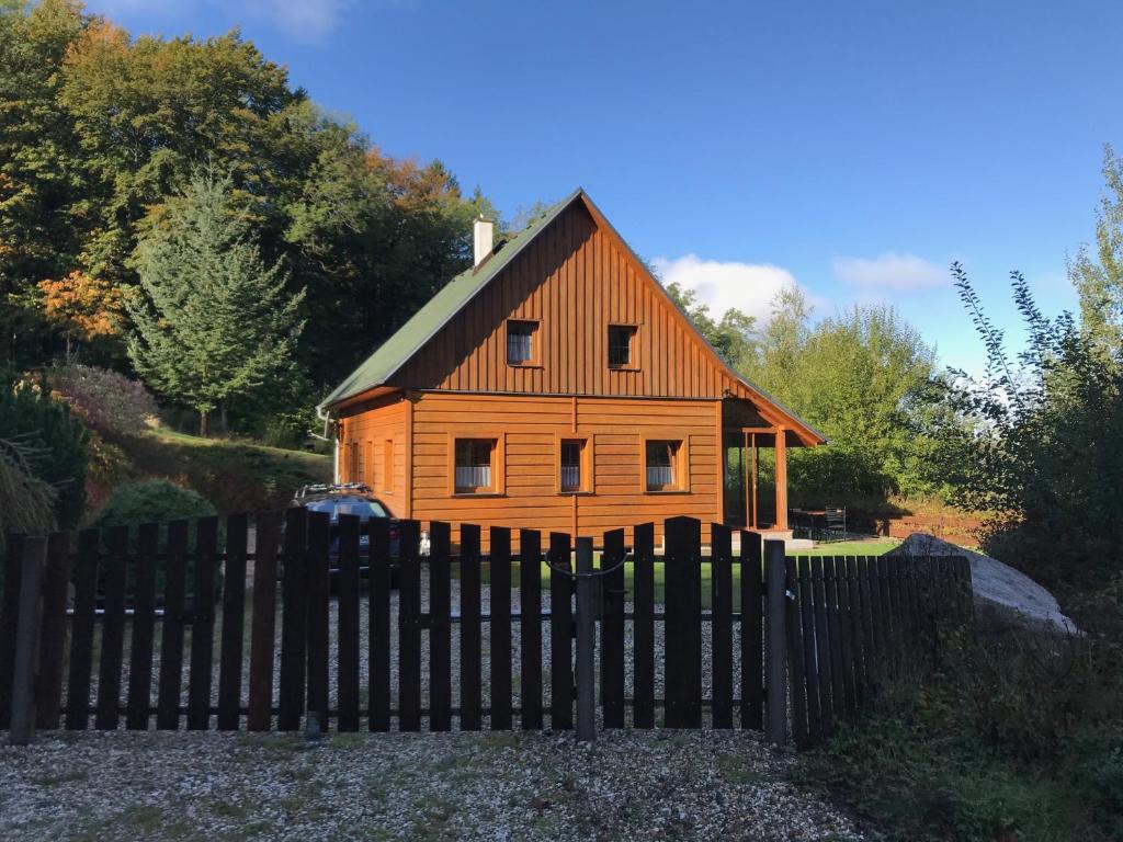 una piccola casa in legno dietro una recinzione di legno di Jizerské hory, Fojtka , chalupa a Mníšek