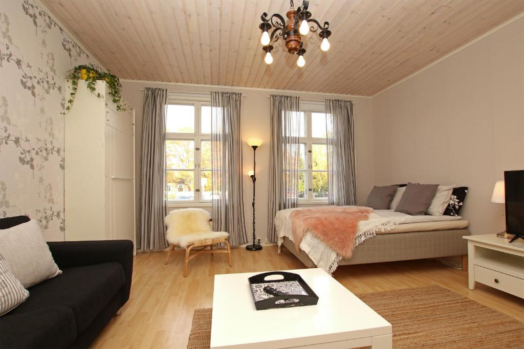 a living room with a bed and a couch at Idyllic central wooden house apartment in Pori