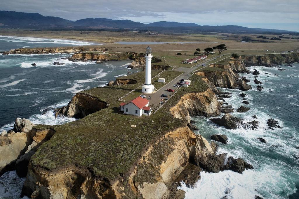 a lighthouse on a cliff next to the ocean at Point Arena Lighthouse in Point Arena