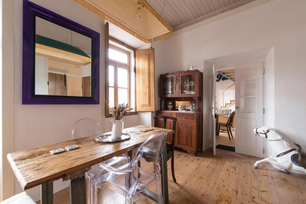 een keuken met een tafel en stoelen in een kamer bij Bohemian Antique Guesthouse in Odeceixe
