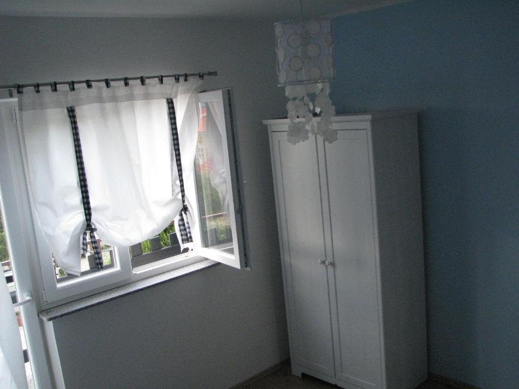 Pokój z oknem, drzwiami i szafką w obiekcie Apartments Relax Punat w mieście Punat