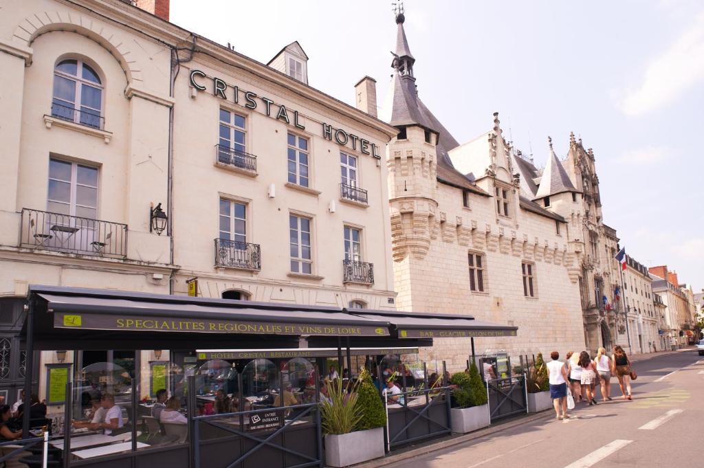 um grupo de pessoas andando em frente a um edifício em Cristal Hôtel Restaurant em Saumur