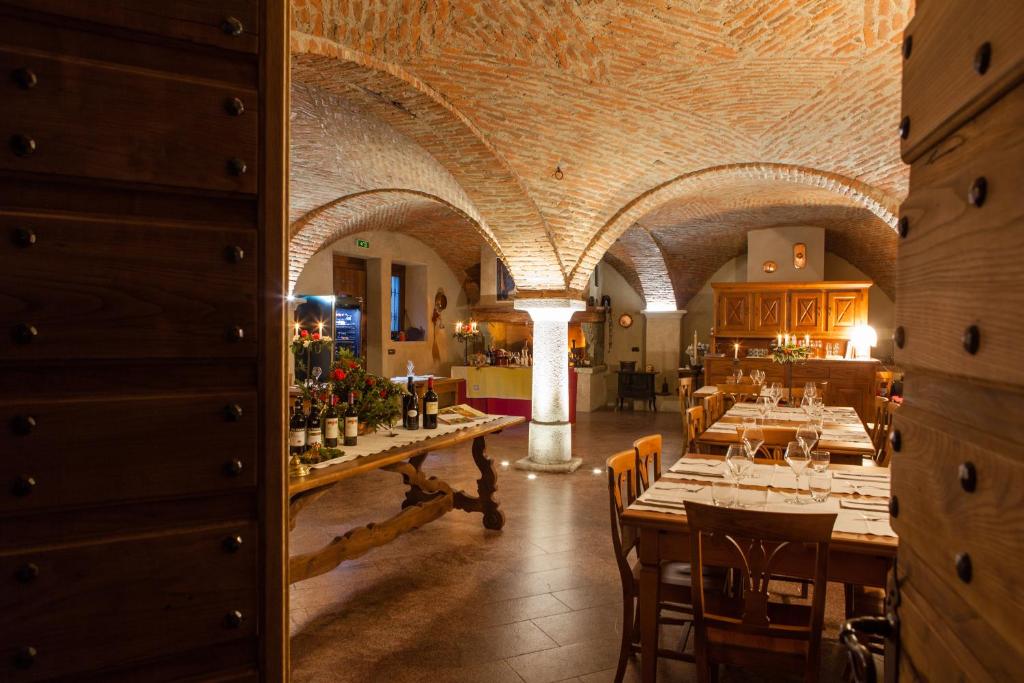 un restaurante con una mesa larga con botellas de vino en A' la Table du Sommelier Chambres d Hôtes & Restaurant, en Saint Vincent