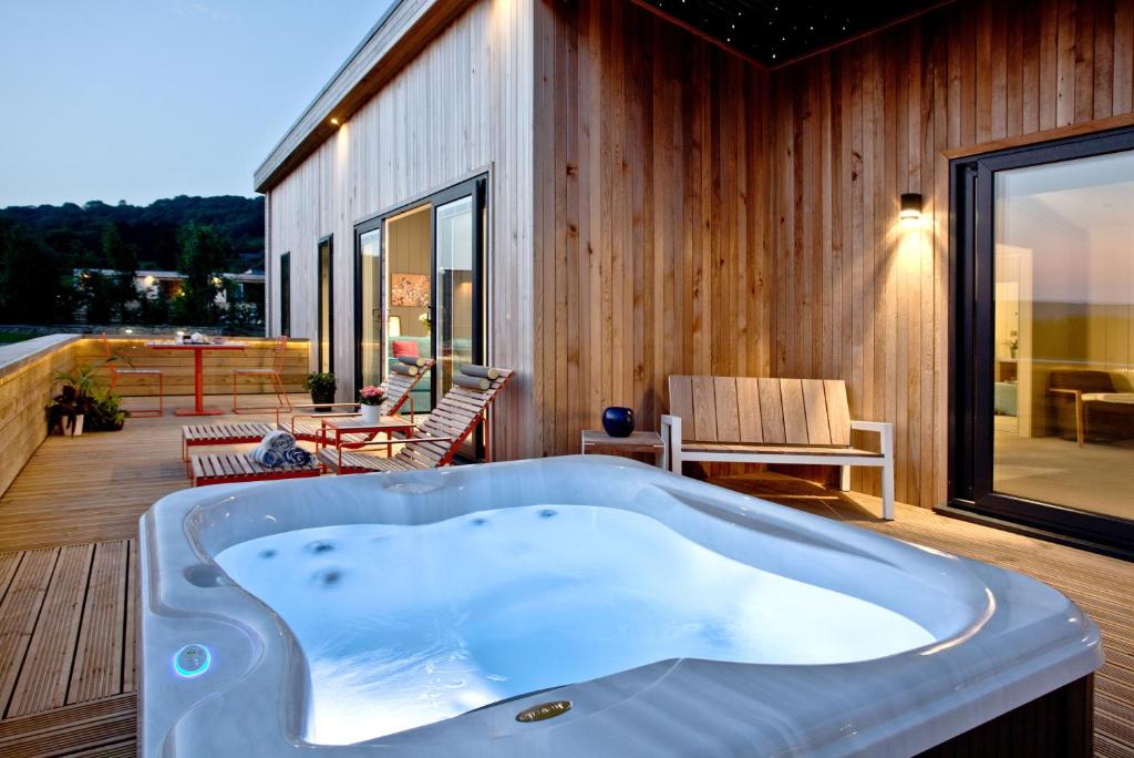 a jacuzzi tub on the deck of a house at Nyland Lodge, Strawberryfield Park in Cheddar