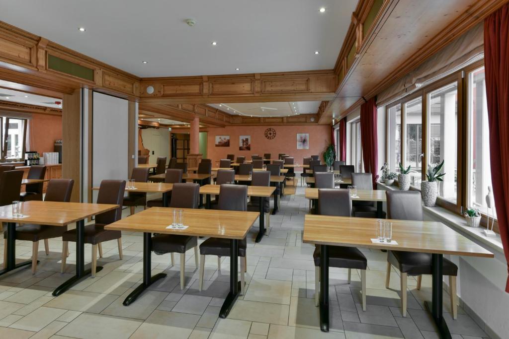 a dining room with tables and chairs and windows at Hotel Belle Vue in Vianden