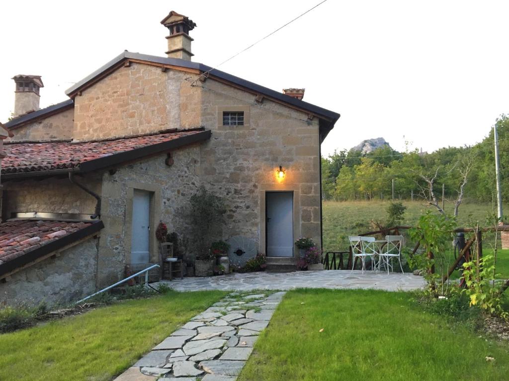 Casa de piedra con patio y mesa en B&B Antico Mulino en Camugnano