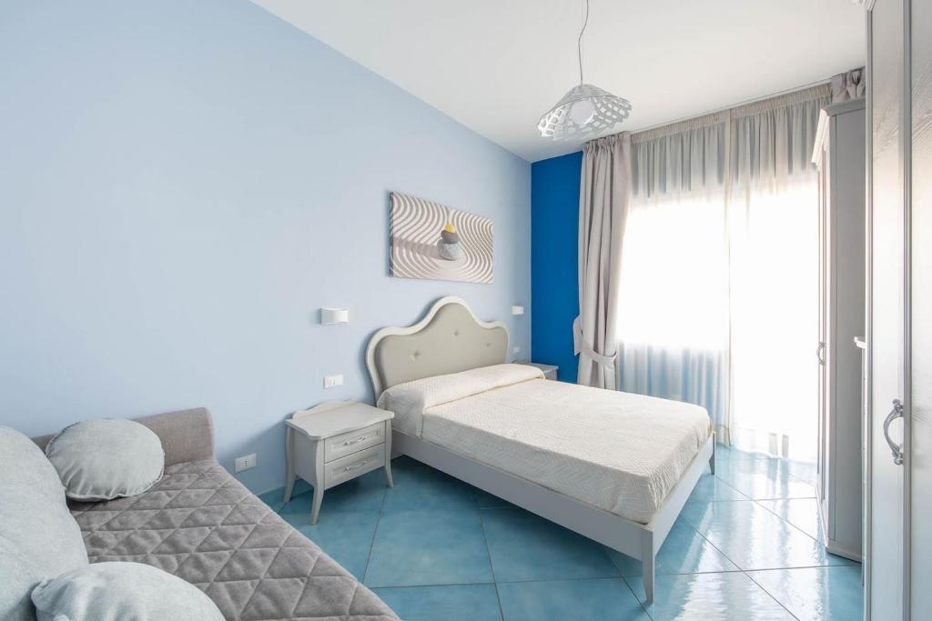 1 Schlafzimmer mit 2 Betten und blauen Wänden in der Unterkunft La Casa del Poeta - Appartamento Positano in Maiori