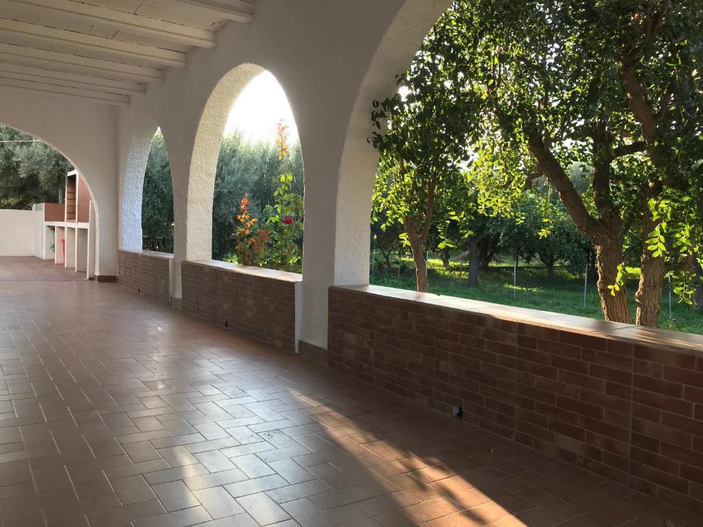 un couloir vide avec des fenêtres cintrées et un sol en briques dans l'établissement El cortijo de la abuela, à Benahadux