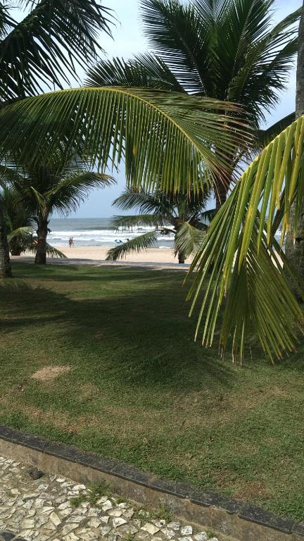 a view of a beach with palm trees and the ocean at Espaço Zen - Equilíbrio da Alma in Guarujá
