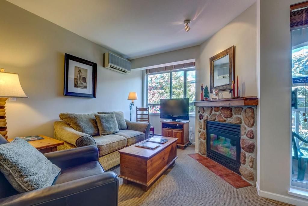 a living room with a couch and a fireplace at Town Plaza Suites by Golden Dreams in Whistler