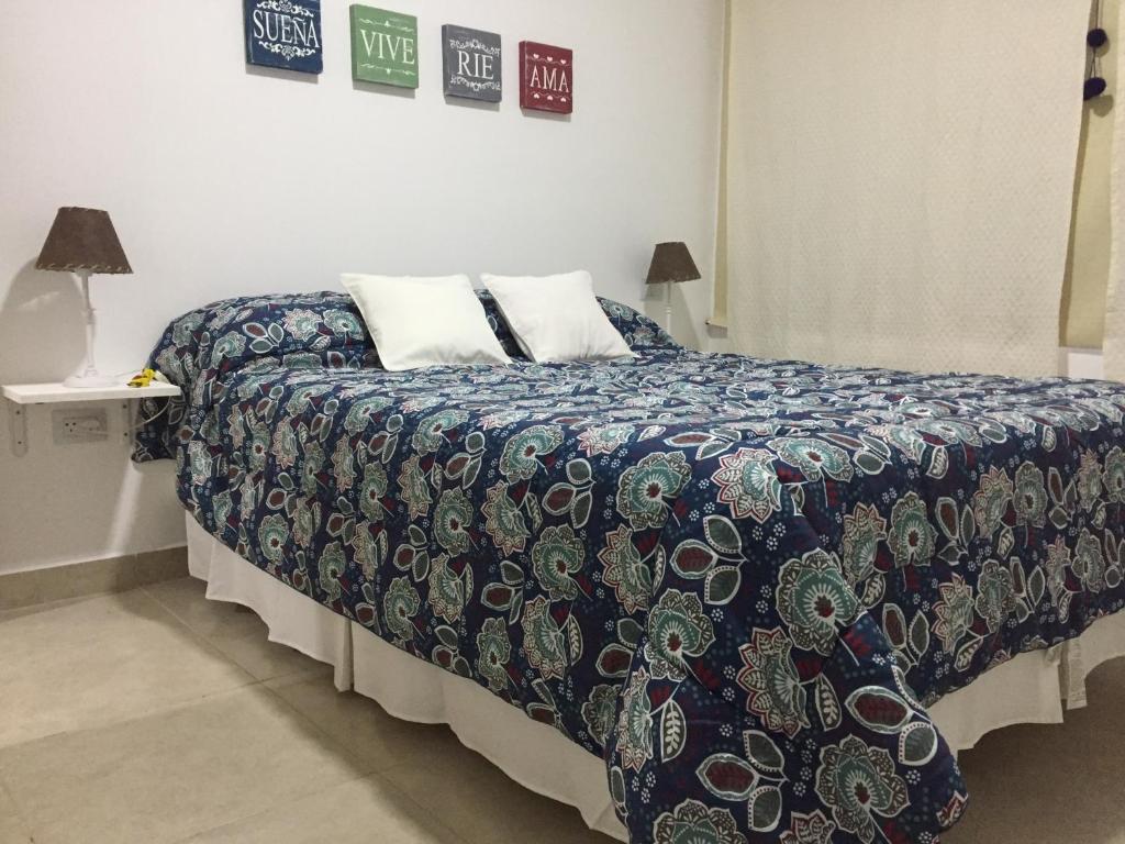 a bedroom with a bed with a comforter on it at Dto nuevo barrio Universitario con wifi y cochera-Check in express in Bahía Blanca