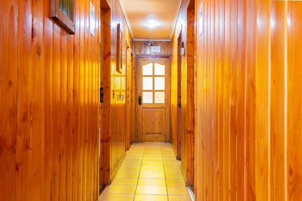a hallway with wooden walls and a door at Hostal Katemu in Villarrica