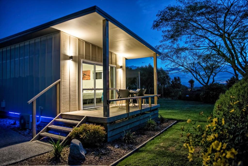 uma pequena casa com um grande deque no quintal em Taupo Debretts Spa Resort em Taupo