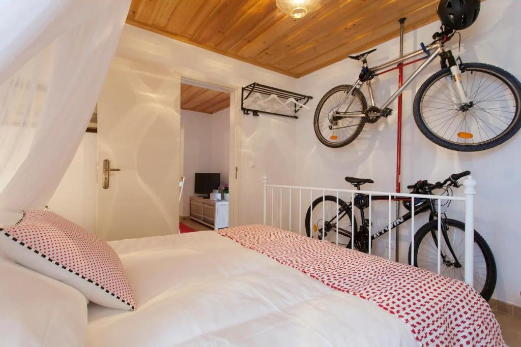 リスボンにあるAlfama Charming Apt with 2 Free Bikes By TimeCoolerのベッドの上の壁に掛かっている自転車2台