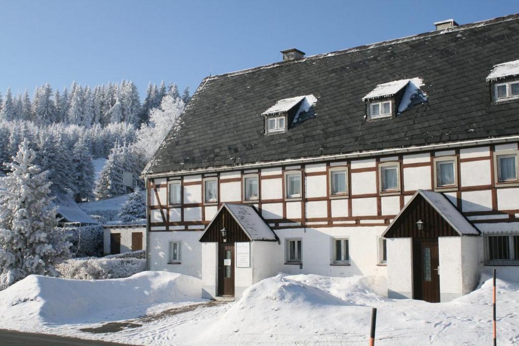 un gran edificio con nieve delante en Ferienhaus Am Skihang, en Kurort Altenberg