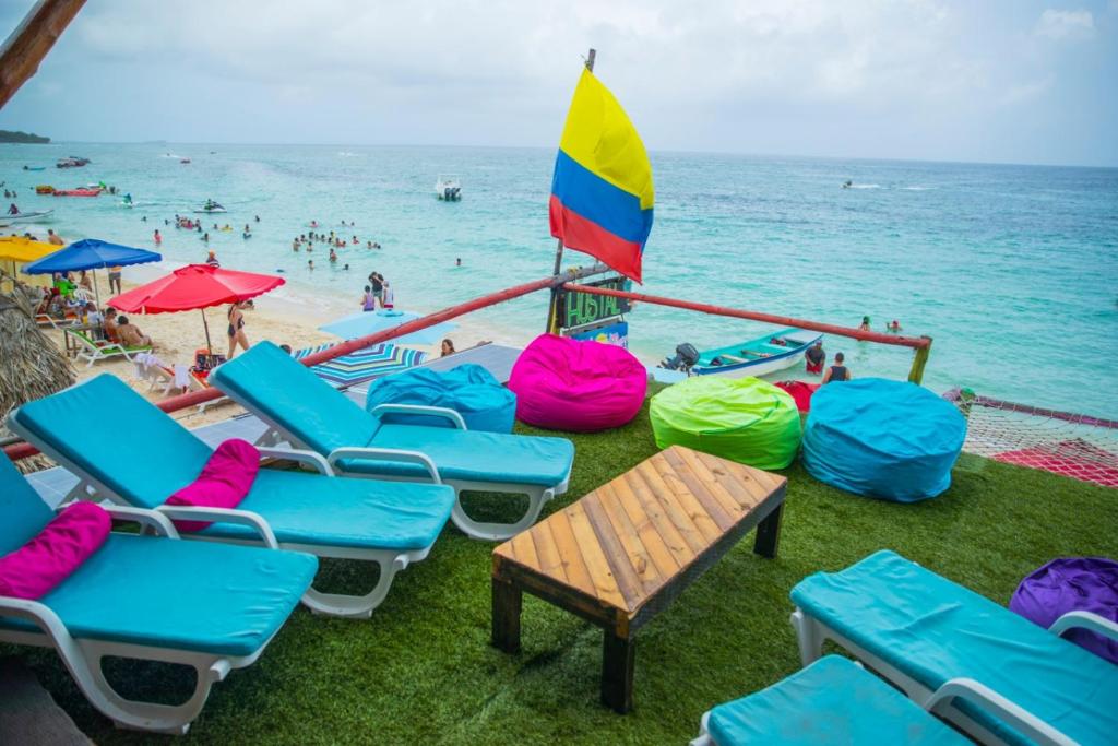 a group of chairs and umbrellas at a beach at Familia Vista al Mar - Baru in Barú