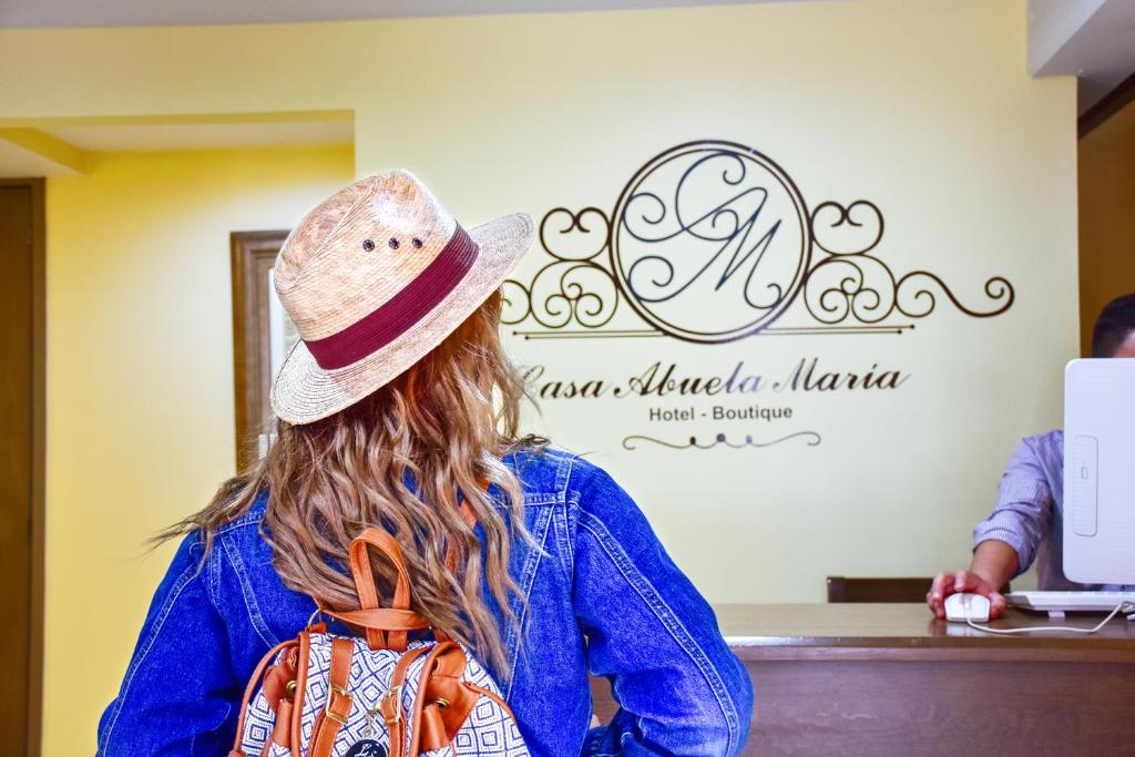 a woman in a hat sitting at a counter at Hotel Boutique Casa Abuela Maria in Oaxaca City