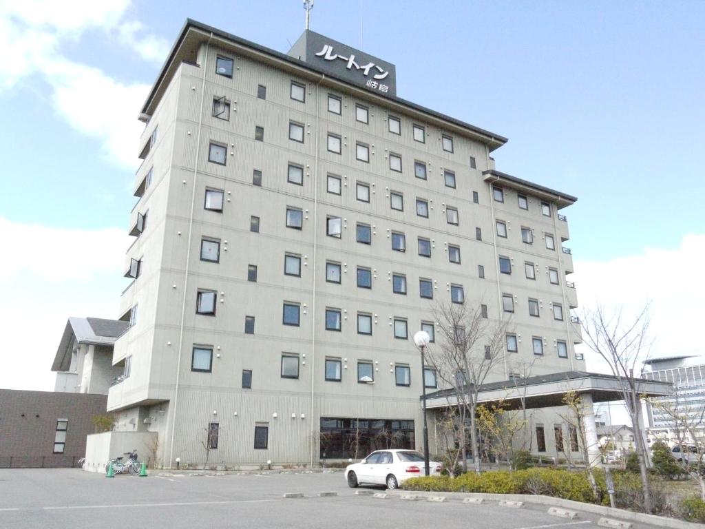 een groot wit gebouw met een bord erop bij Hotel Route-Inn Gifukencho Minami in Gifu